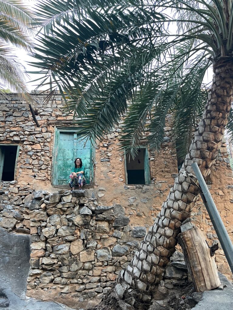 The front view of a traditional mud home with light green doors.