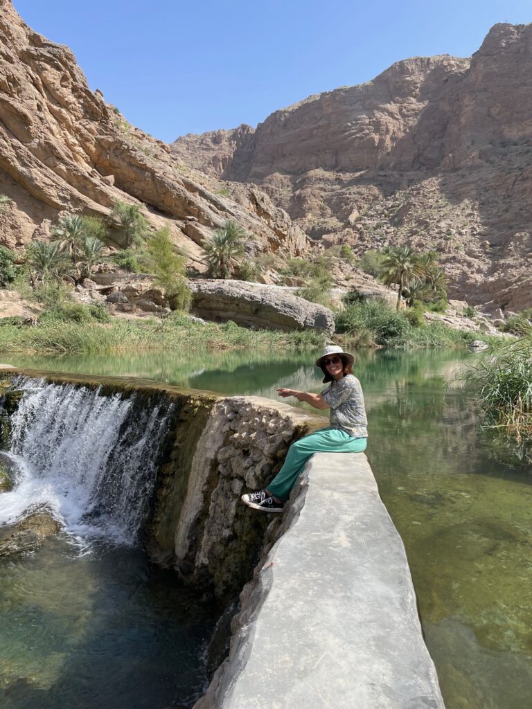 A small waterfall and a turquoise-colored wadi pool