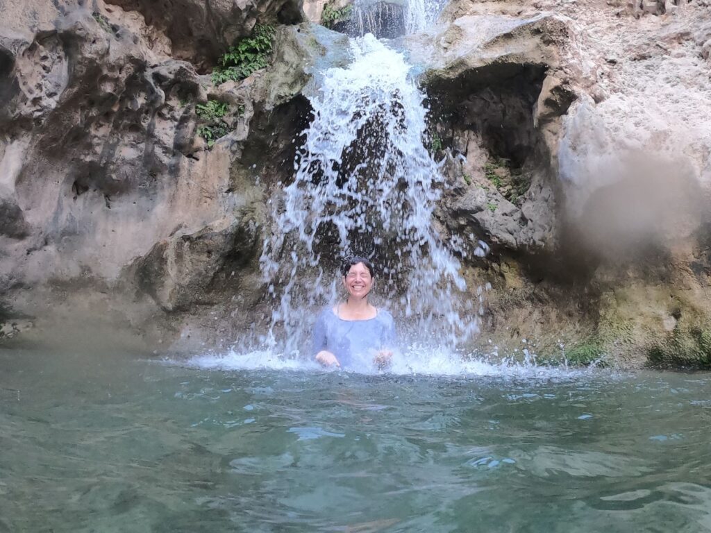 Erin underneath a waterfall. 6 wadis to cool off