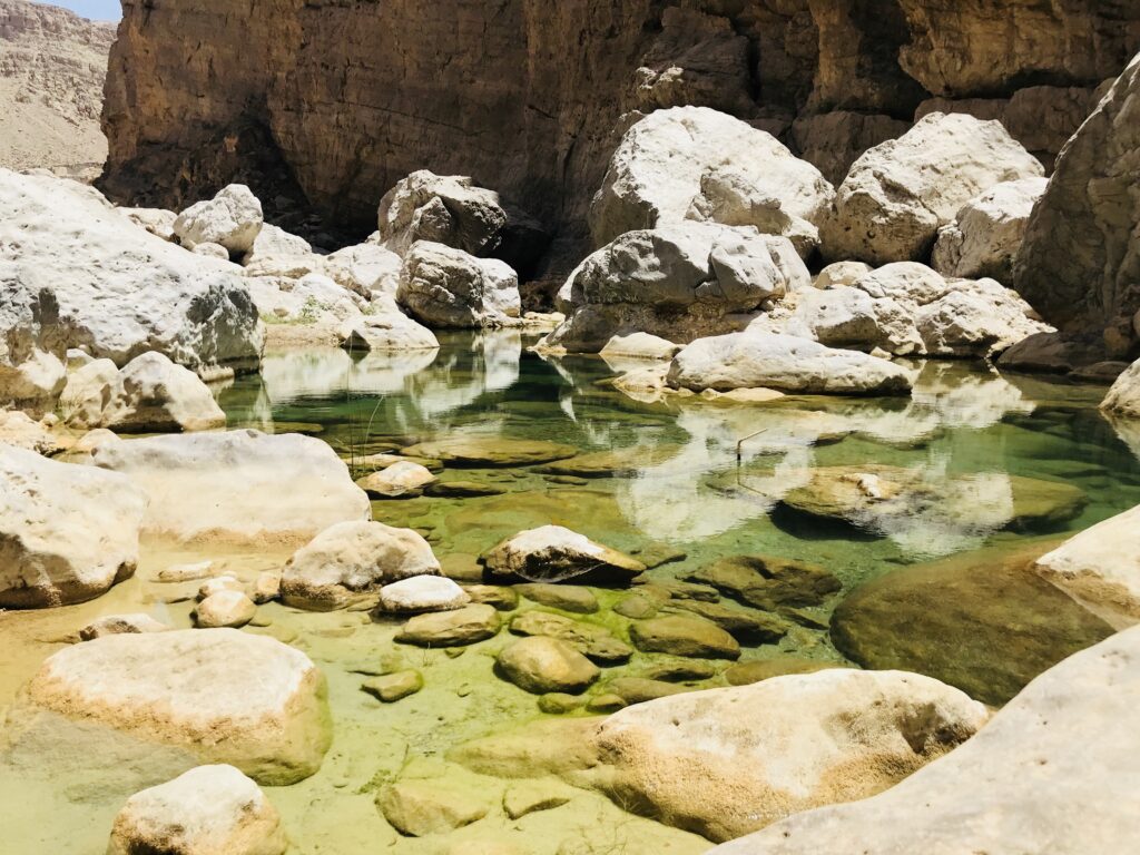 A small pool surrounded by rocks at Wadi Hawar. 6 wadis to cool off